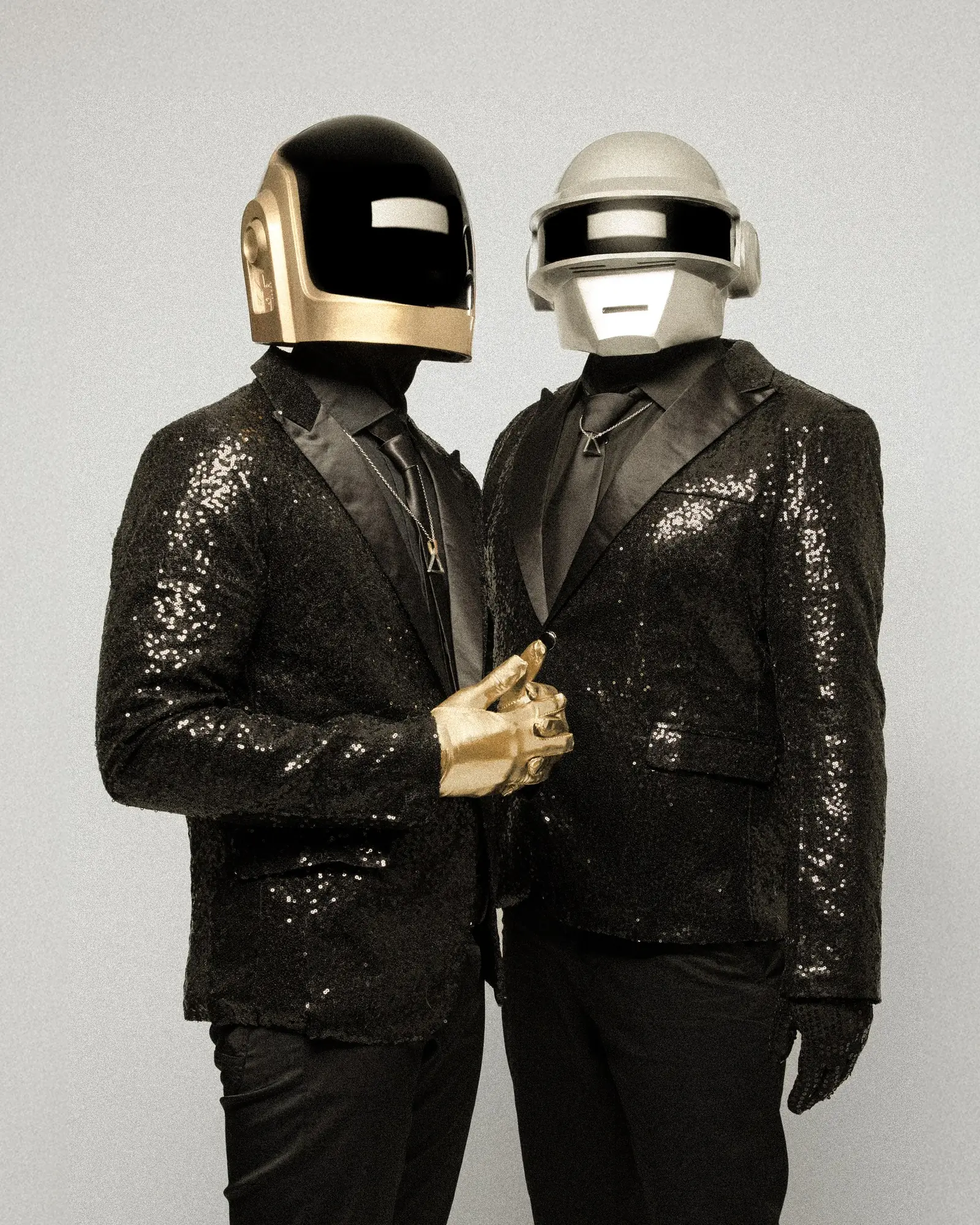 The gold-helmet performer adjusting the other's jacket